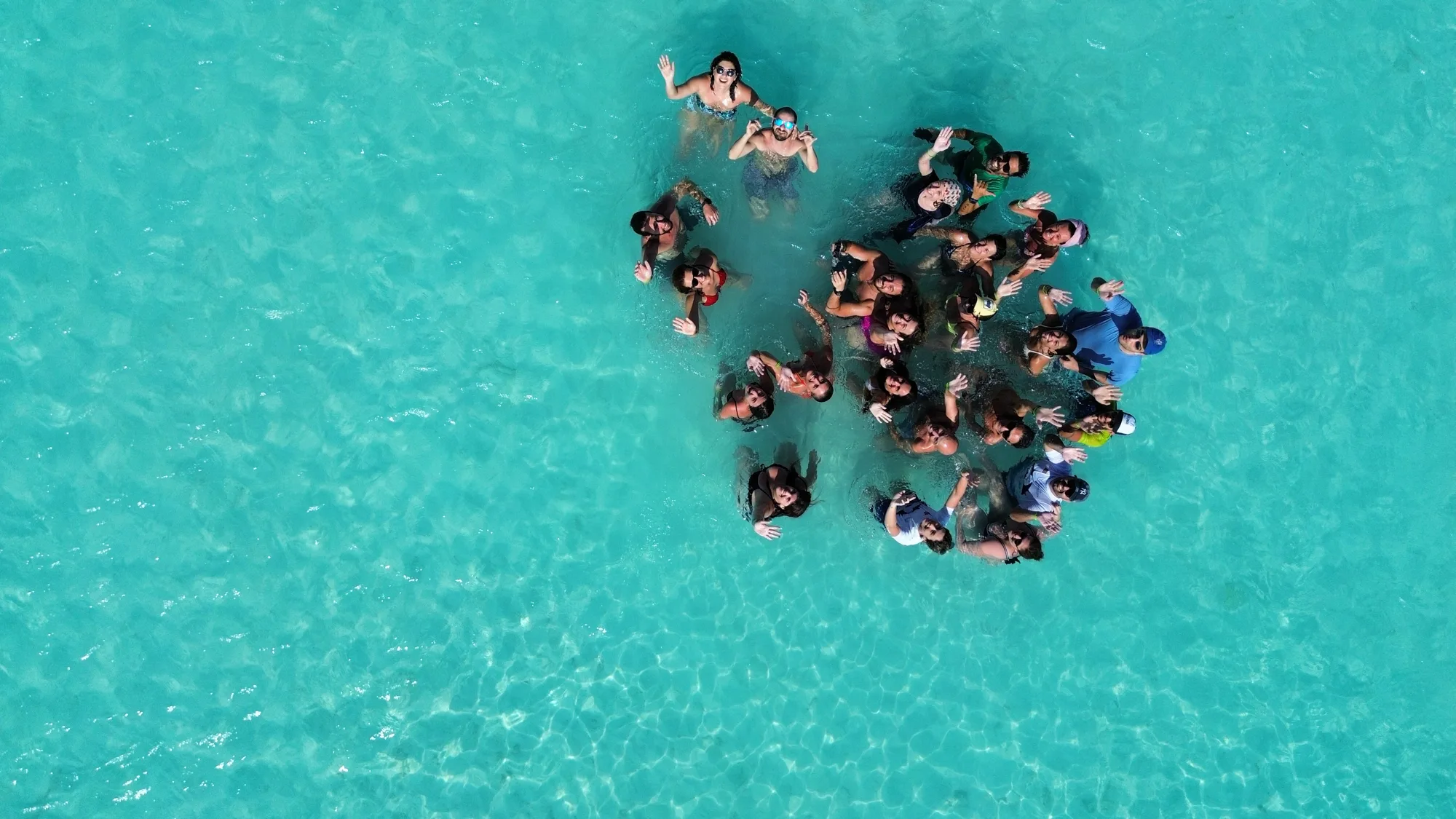 Viaggio di gruppo alle Maldive con Filoquita: i partecipanti in cerchio nella laguna turchese di Keyodhoo, vista dall’alto